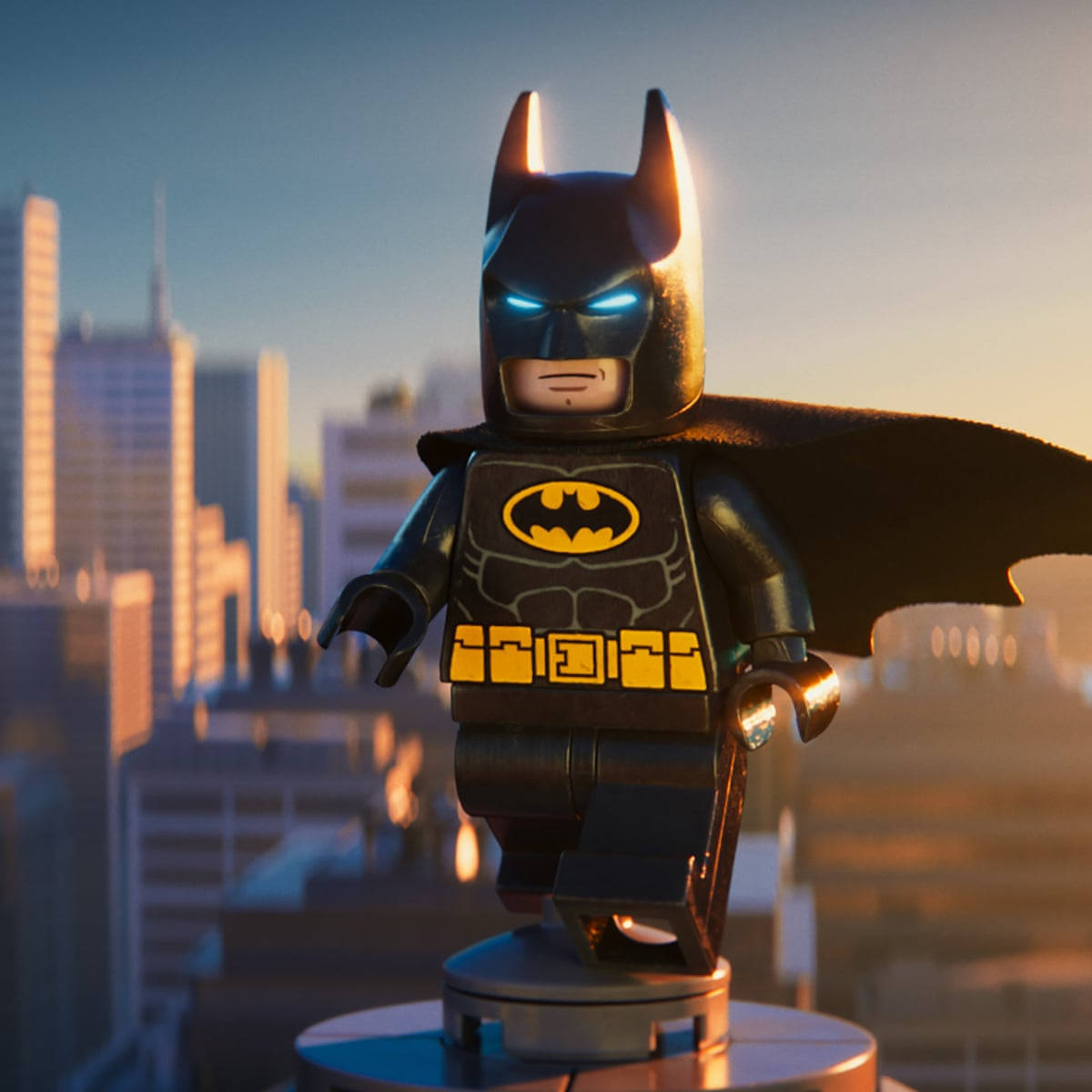 LEGO蝙蝠俠人偶站在基座上俯瞰夕陽下的城市。 — 樂高 GIF 壁紙