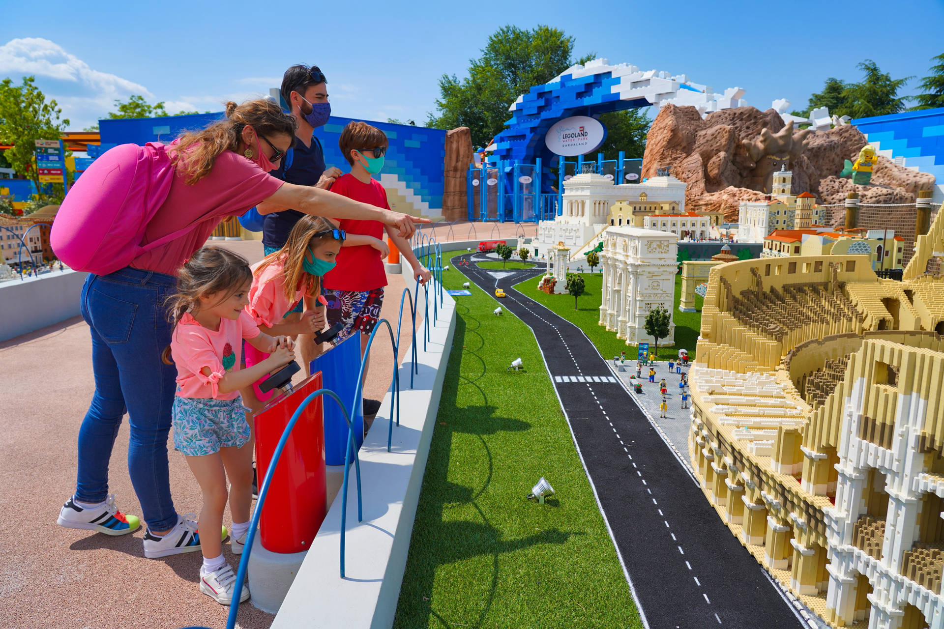 戴著口罩的家庭在主題公園觀看LEGO羅馬微型模型。