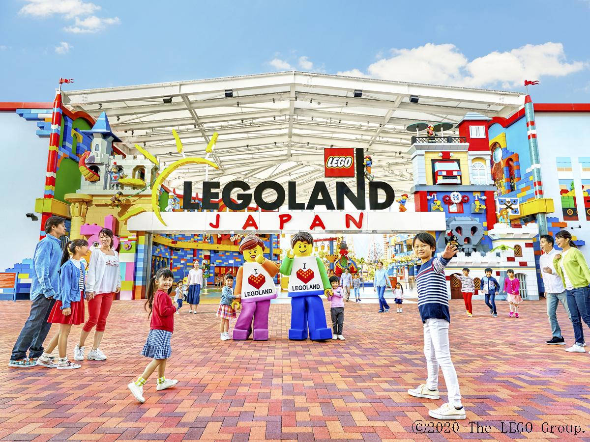家庭和孩子們在 LEGOLAND Japan 入口處與 LEGO 迷你人偶微笑。