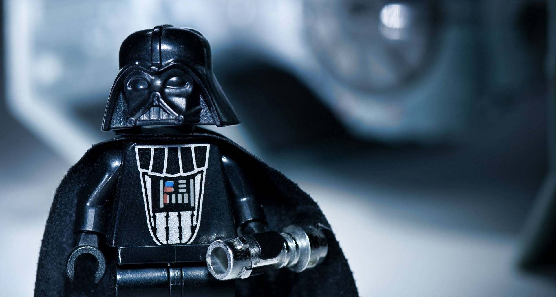 LEGO 黑武士在科幻場景中手持光劍柄。