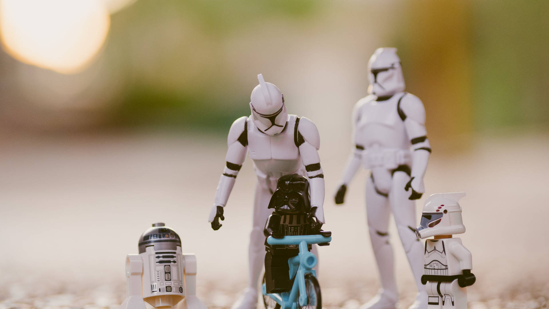 星際大戰玩具人偶，達斯維達騎單車，被暴風兵和R2-D2包圍。