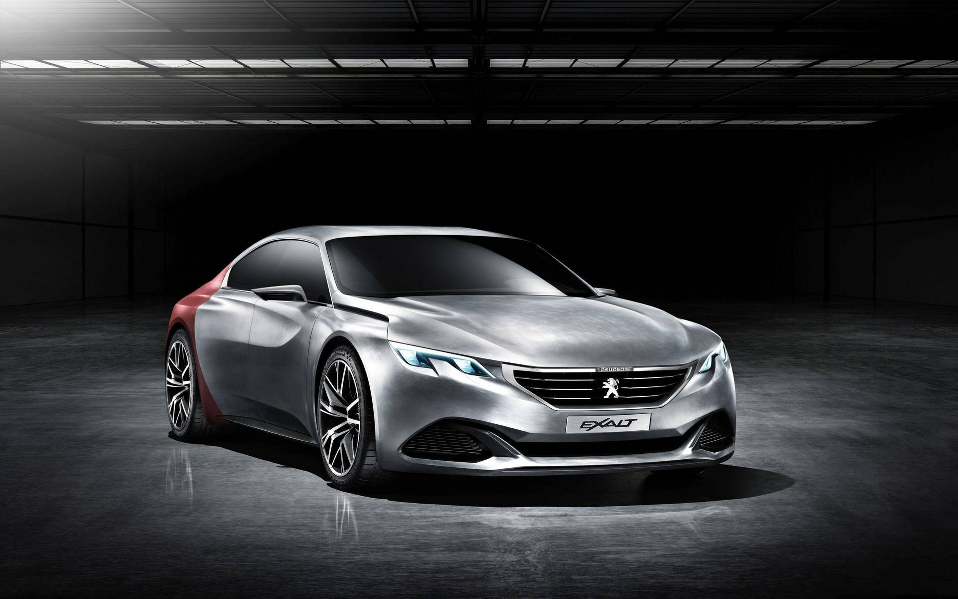 時尚的銀紅色Peugeot Exalt概念車在黑暗的工業車庫中，帶有戲劇性的燈光。