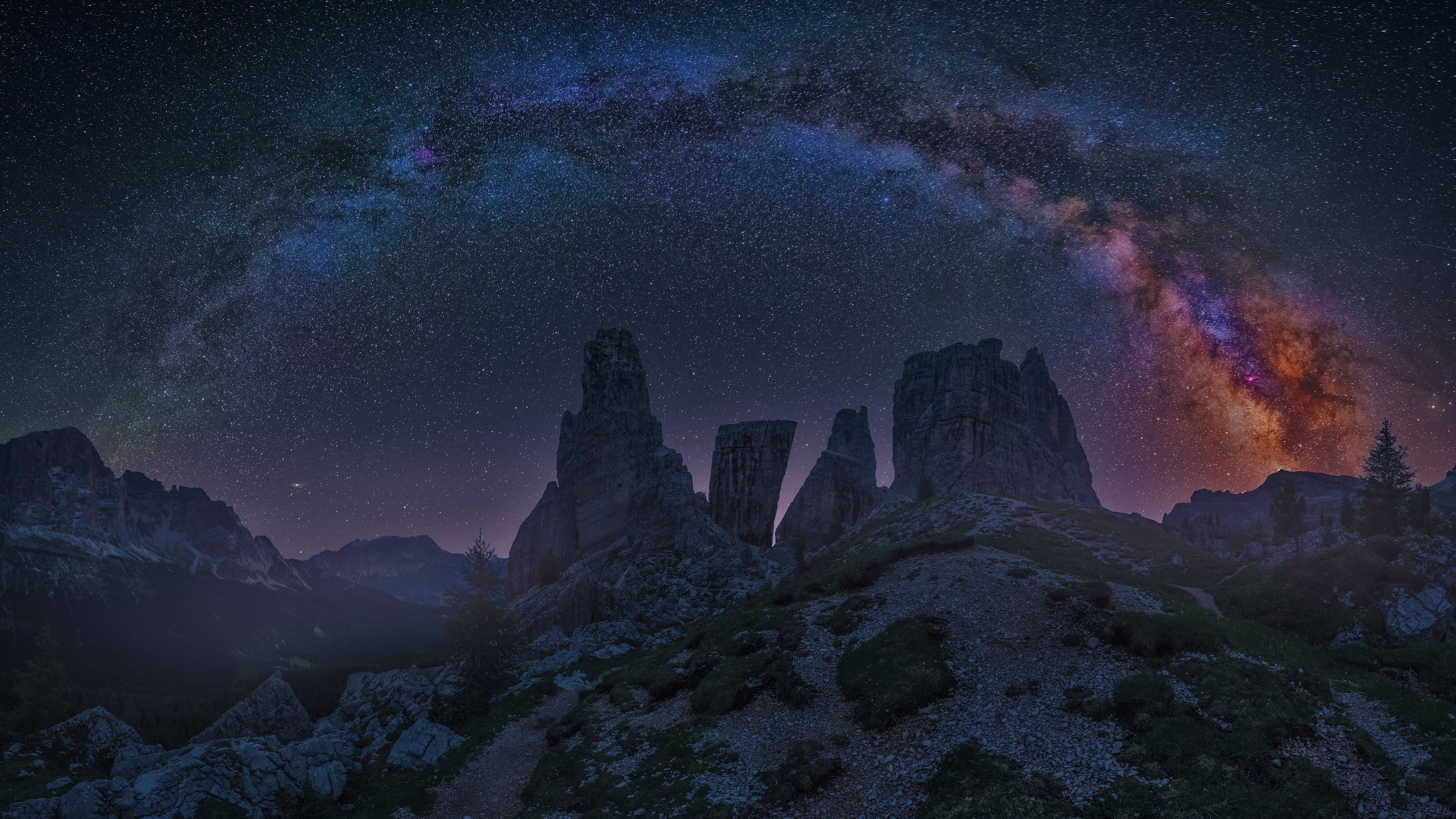 標誌性多洛米蒂山脈暗調4K 壁紙 — 雄偉的山脈在充滿活力的星空下呈現剪影，銀河拱橋般橫跨其上。