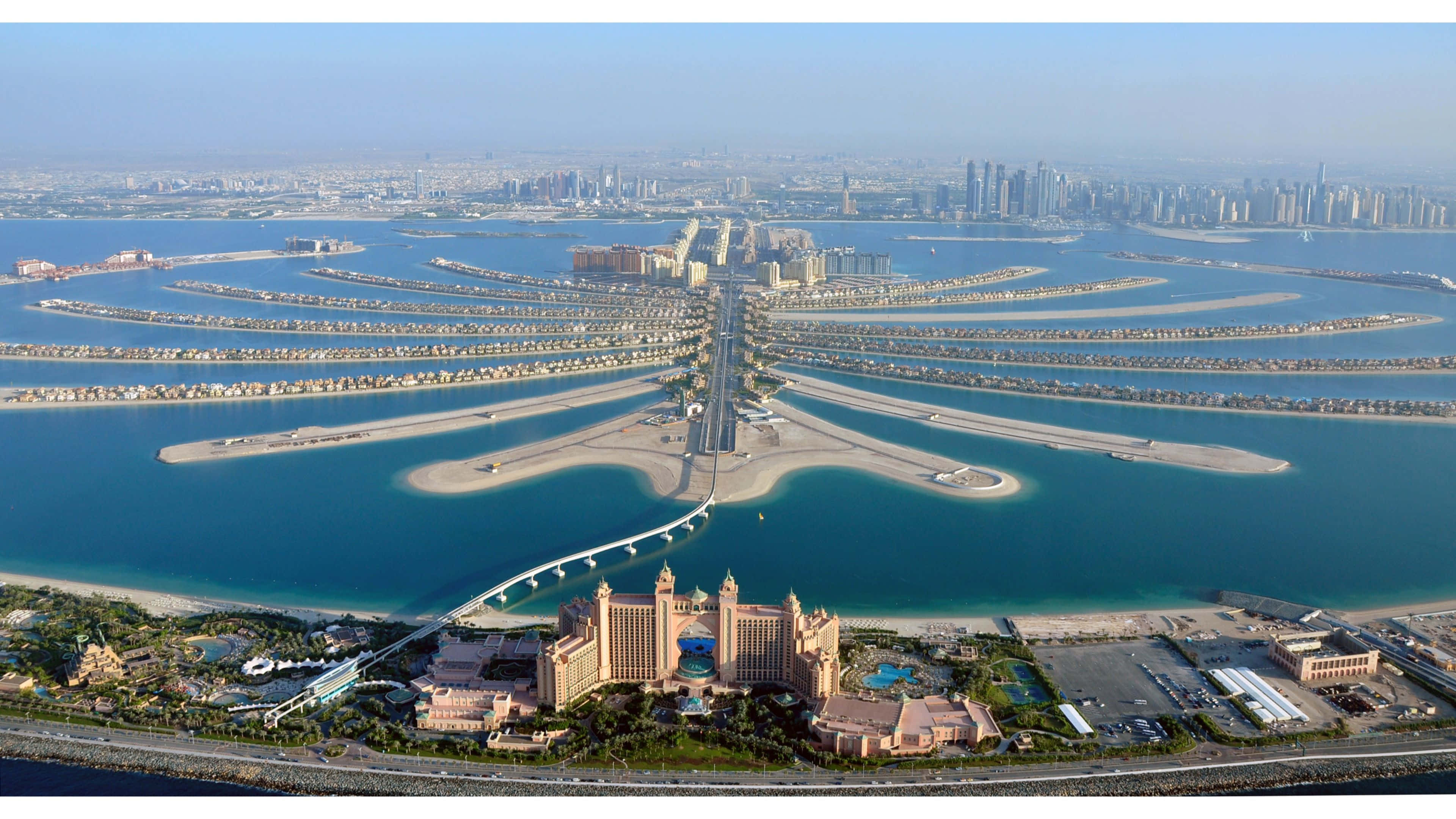 Dubai 桌布 壁紙 — 標誌性棕櫚島的鳥瞰圖，呈現棕櫚樹形狀，豪華酒店被碧綠海水環繞。