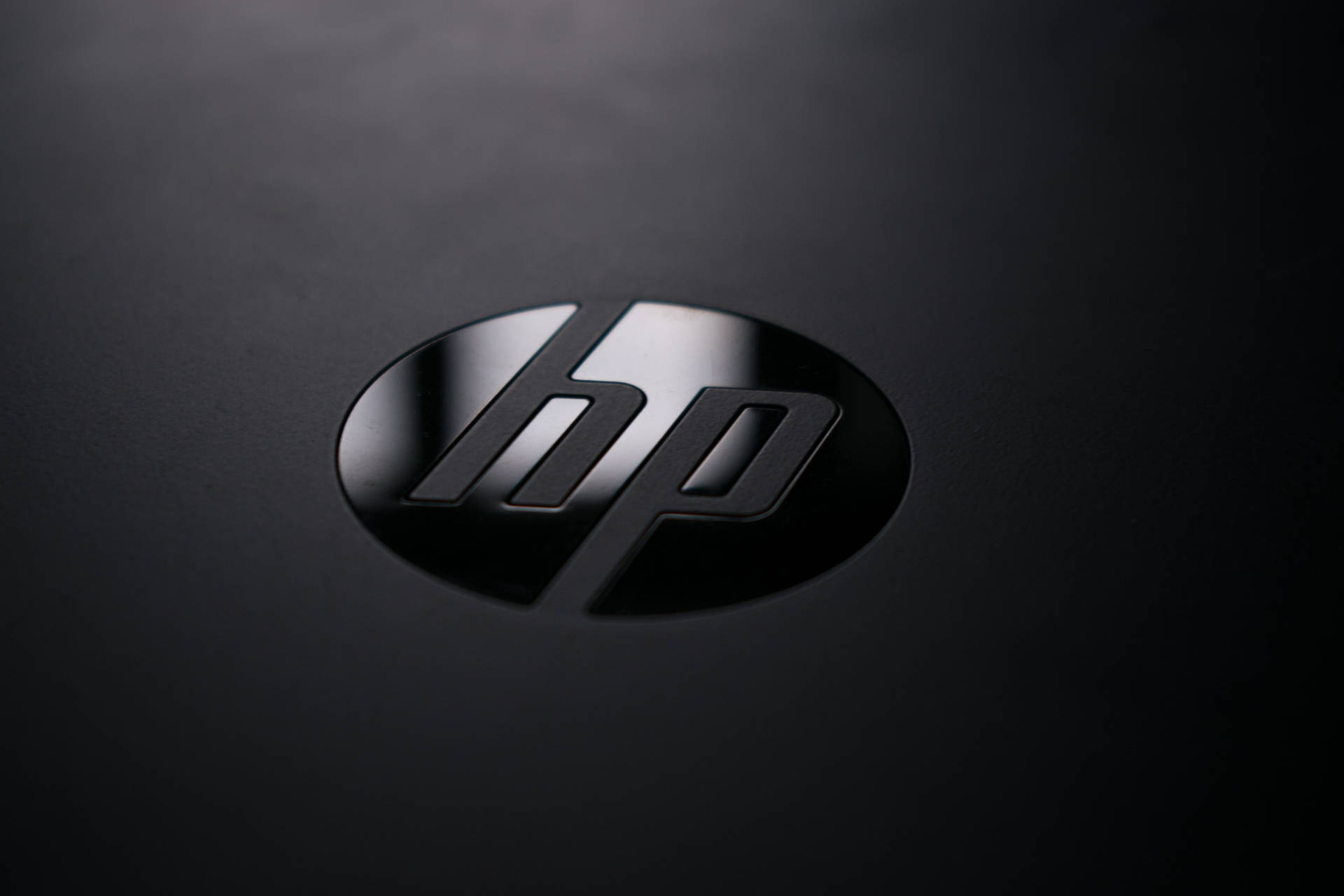 黑色設備表面上的 HP 標誌，帶有反射高光。