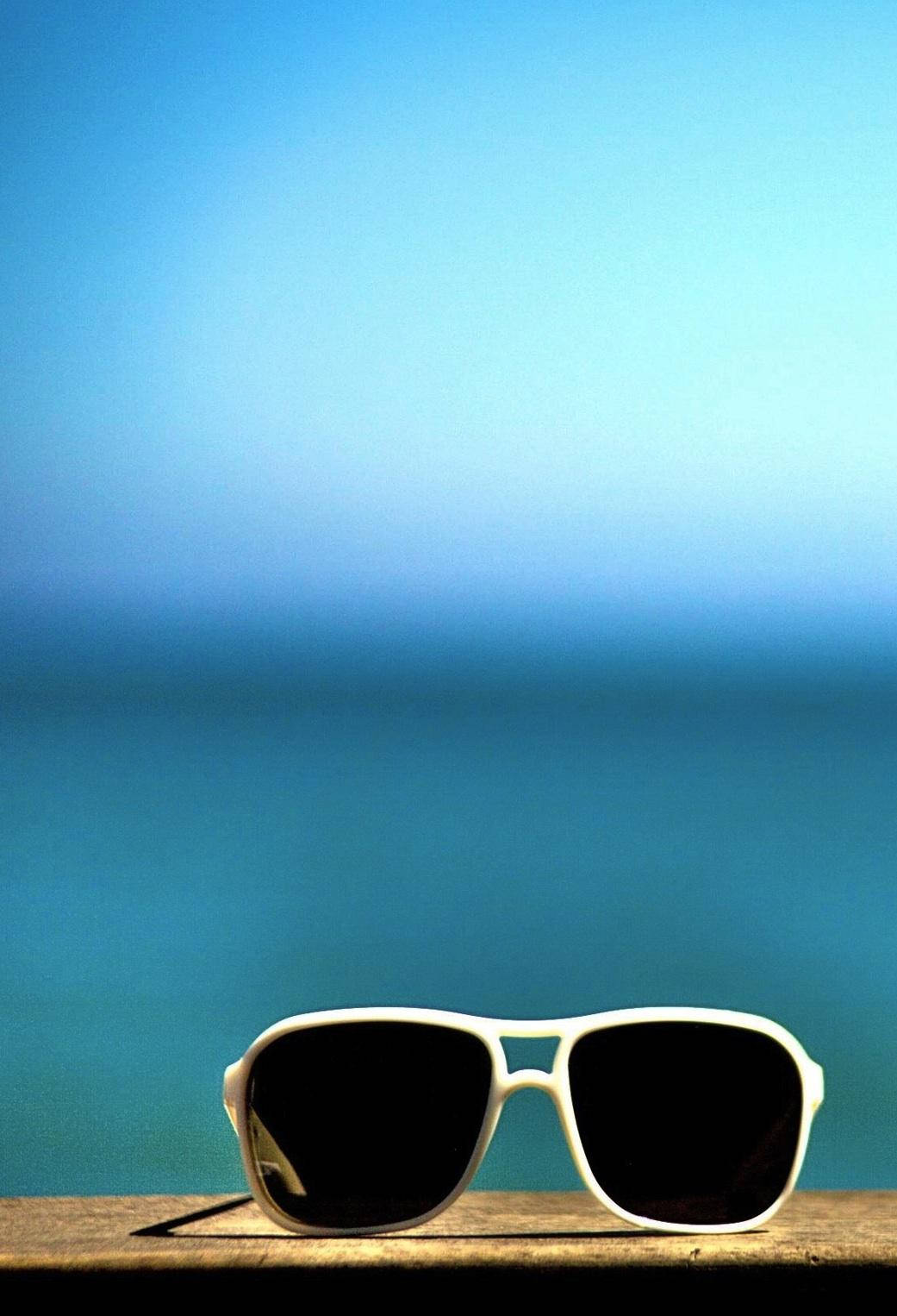 海邊木頭上的白色太陽眼鏡