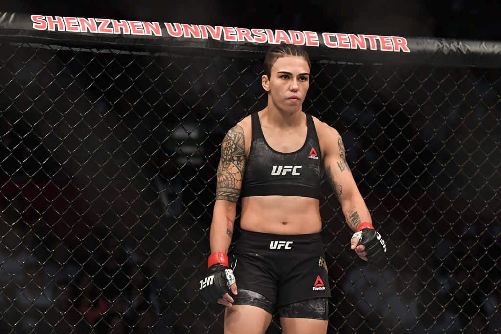女性MMA拳手穿著UFC裝備，站在深圳大運中心體育館的籠內。