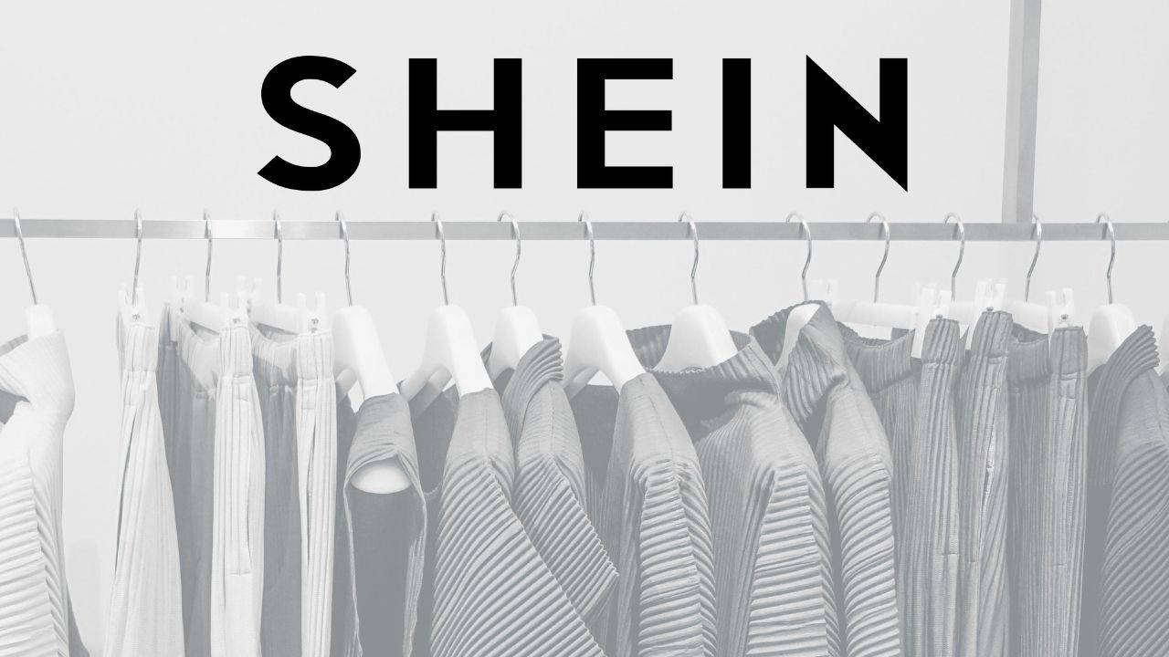 SHEIN品牌標誌位於掛有百褶衣物的衣架上方，呈灰階色調。