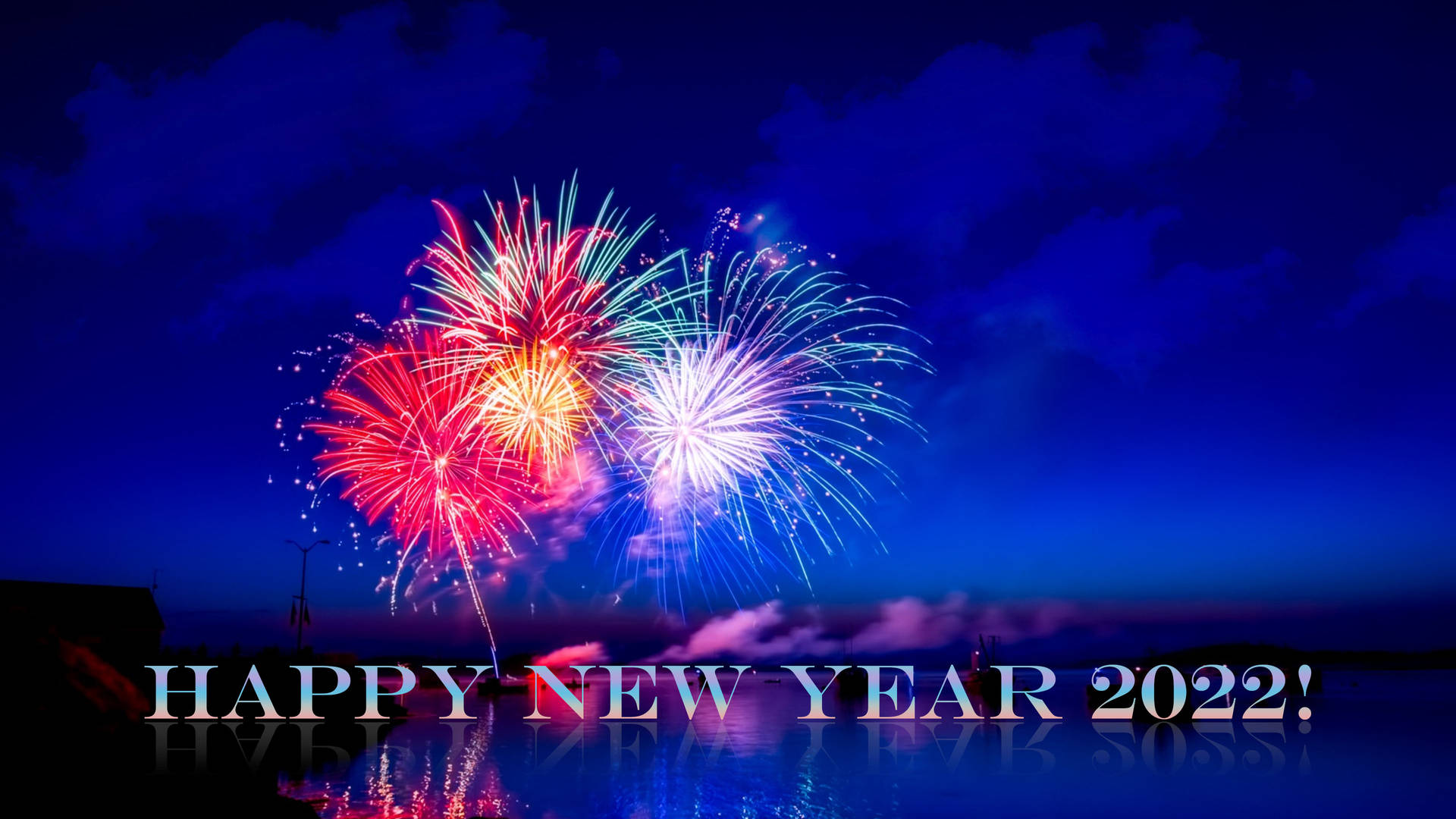水上煙火表演，下方反射出「Happy New Year 2022!」文字。