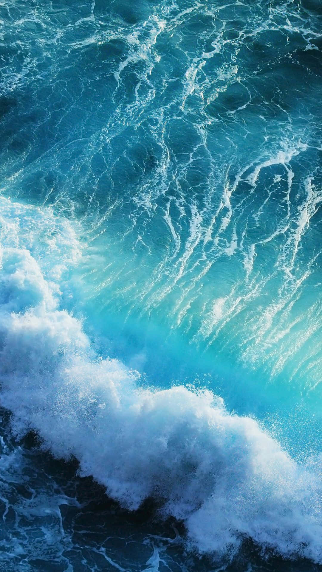 標題：壯麗深藍水景背景 壁紙 — 一個動態的特寫鏡頭，捕捉了綠松石色的海浪拍打著深藍色的大海，激起白色泡沫。