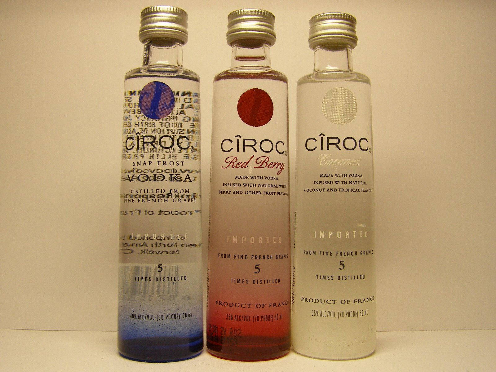 三瓶帶有藍色、紅色和白色標籤的 Cîroc 伏特加酒放在架子上。