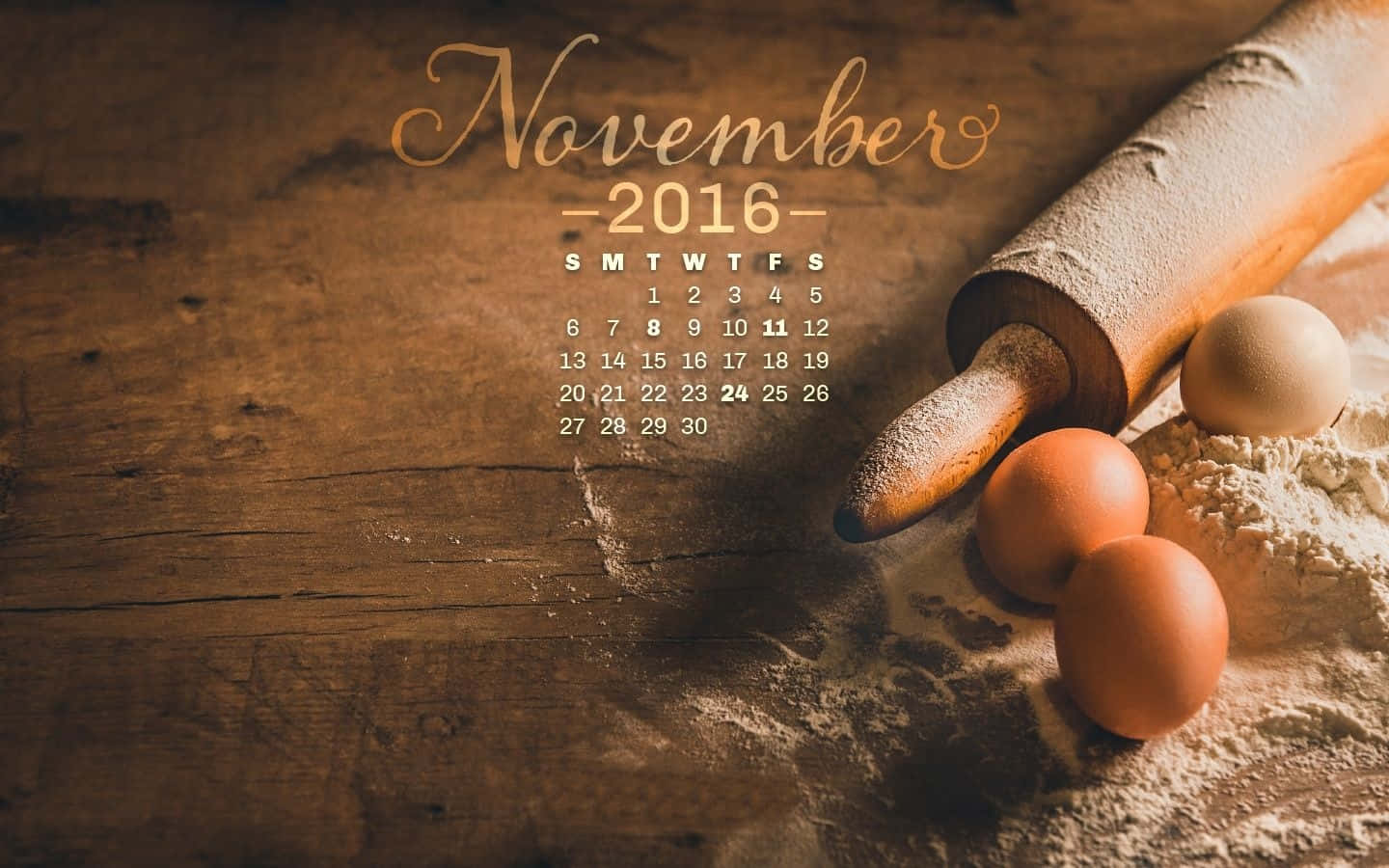 2016年11月日曆與木質表面上的烘焙工具。