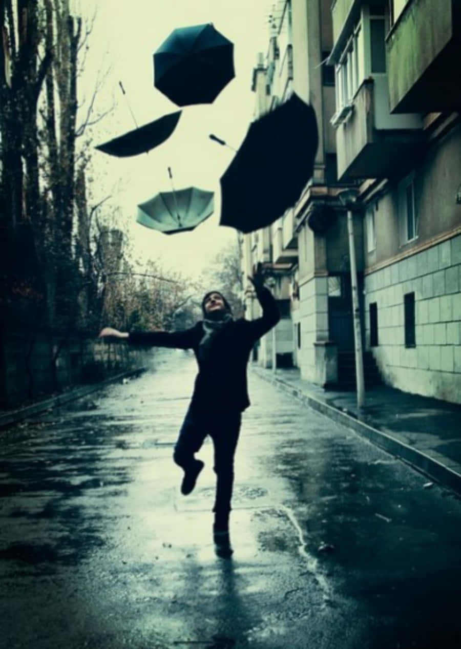 人在城市小巷中於雨中跳躍，雨傘漂浮。