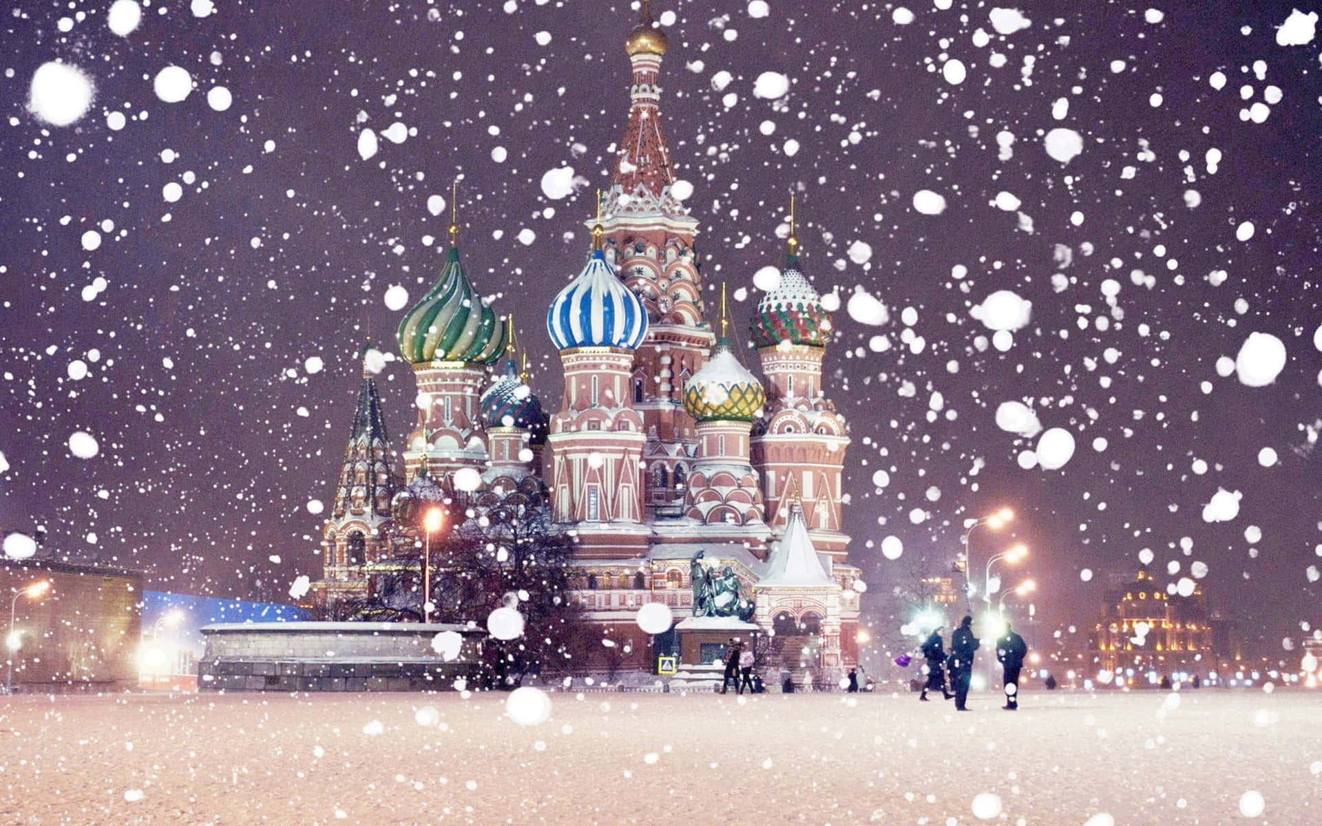 標題：莫斯科克里姆林宮聖巴西爾大教堂的壯麗風景 壁紙 — 雪花在莫斯科聖瓦西里主教座堂的燈光穹頂上空飄過夜空。