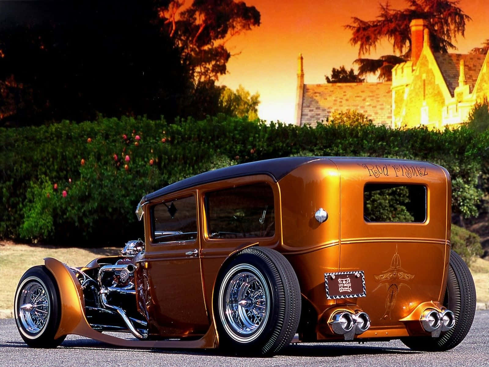 定制青銅色hot rod，帶有鍍鉻裝飾，停在夕陽下靠近石屋。