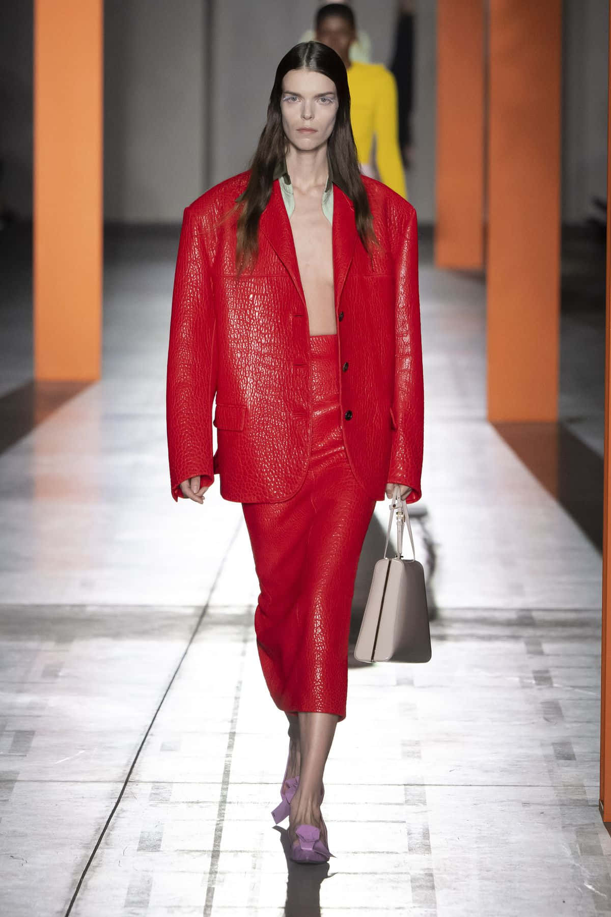 Beautiful Fashion 桌布 壁紙 — 模特兒身穿大膽的紅色紋理西裝，搭配紫色高跟鞋和米色手袋，在時裝展上走秀。