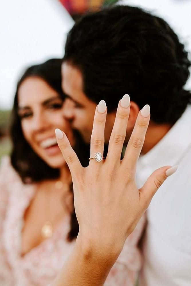 一對微笑的情侶慶祝訂婚，女士手指上戴著鑽石戒指。