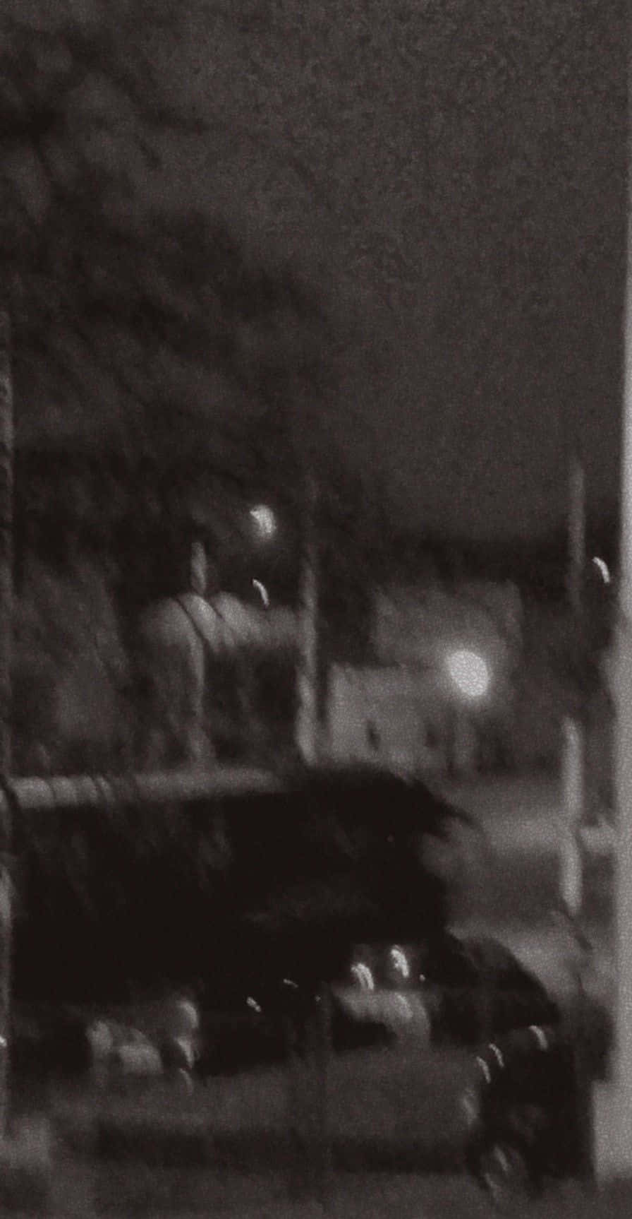 模糊的夜晚街道，有汽車和遠處燈光。