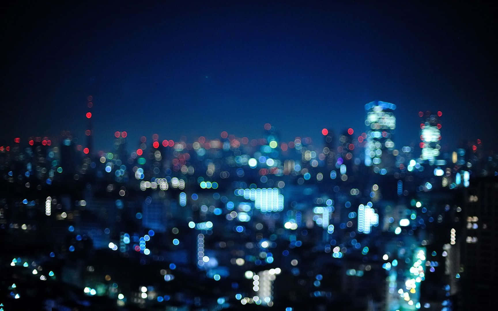 夜晚的城市燈光模糊成發光球體，映襯著黑暗的天空。