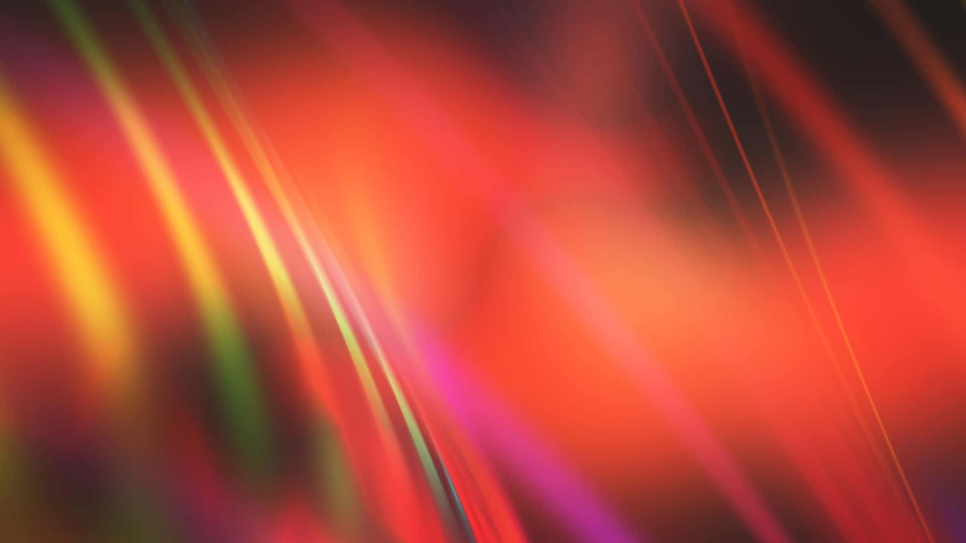 橘色與淺紅漸層背景 壁紙 — 充滿活力的抽象紅色、橙色和紫色光條在深色背景上動態模糊。