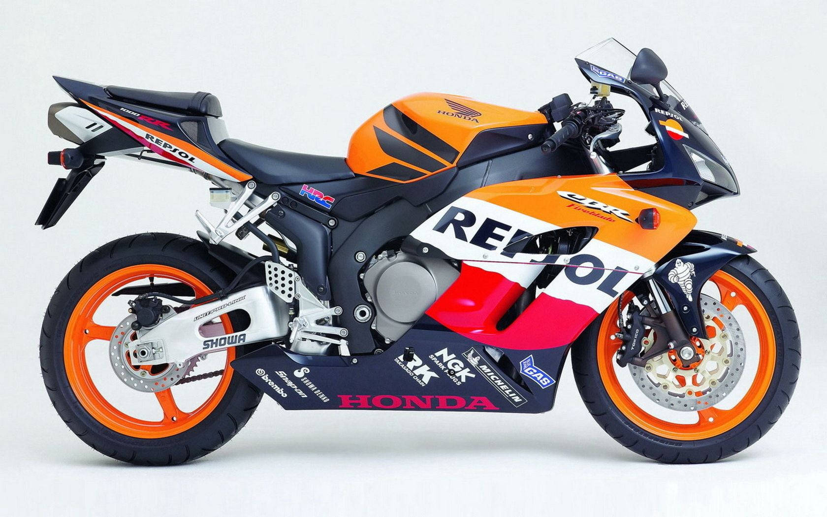 一台本田CBR賽車摩托車，橙紅黑配色，白色背景。