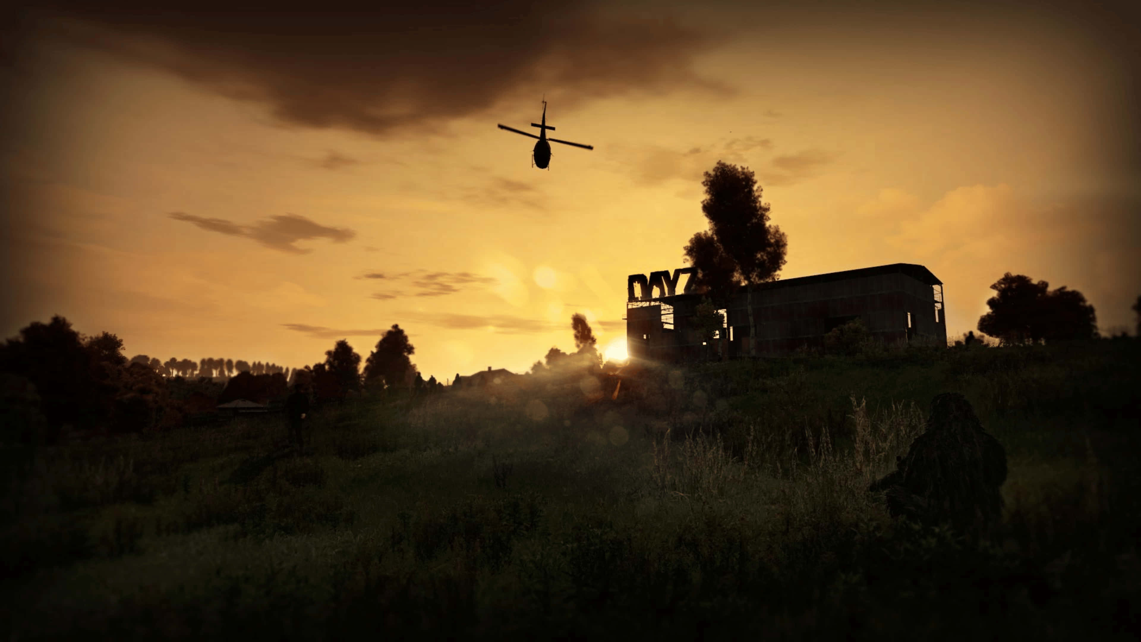 橙色天空下的直升機 4K DayZ Epoch Mod 背景 壁紙 — 一架直升機在金色夕陽的映襯下，盤旋在草地上一座廢墟建築的上空。