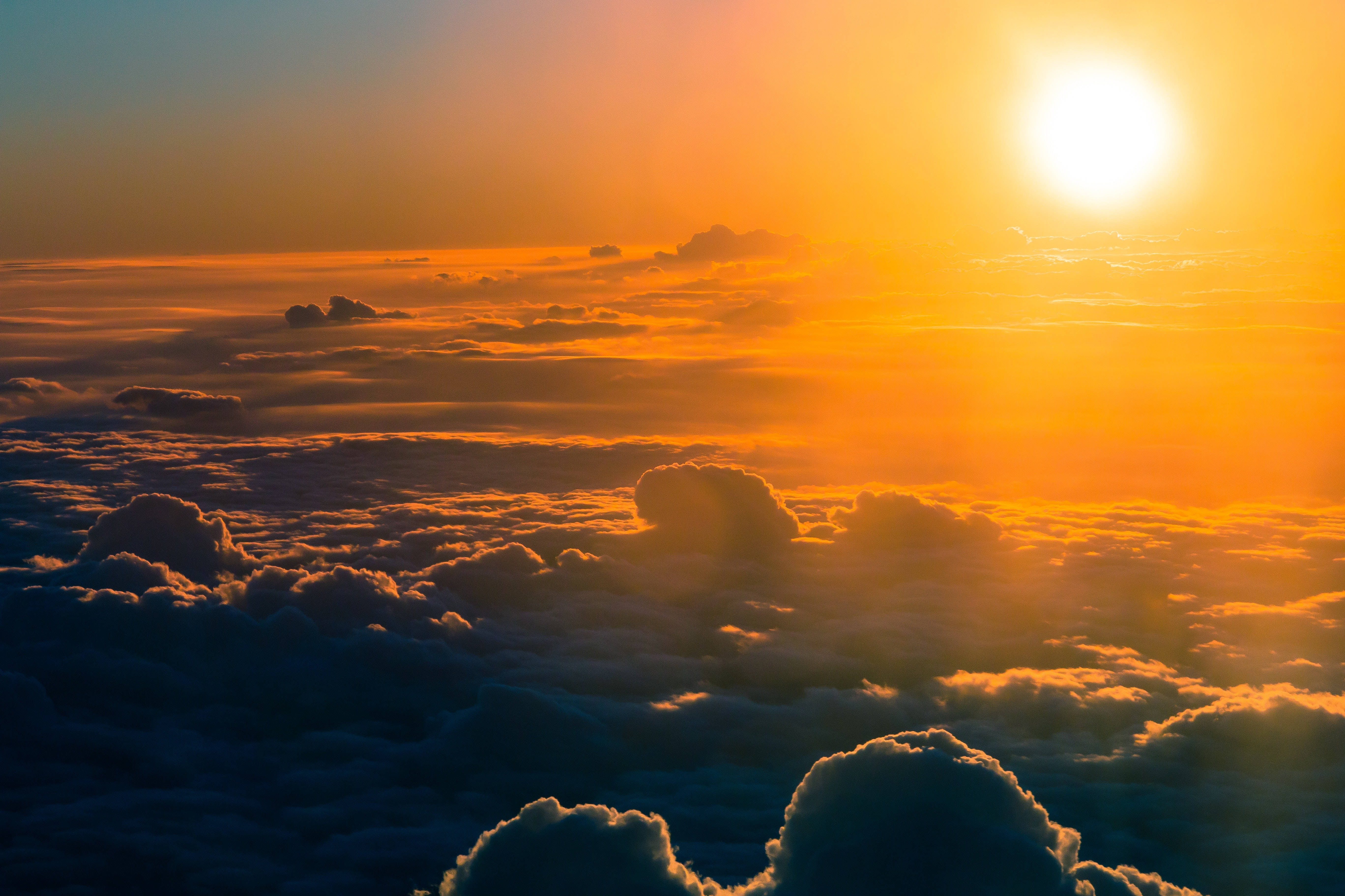 橙色太陽雲背景 壁紙 — 日出將雲彩染成火橙色和深藍色，從無盡的天空之上觀看。
