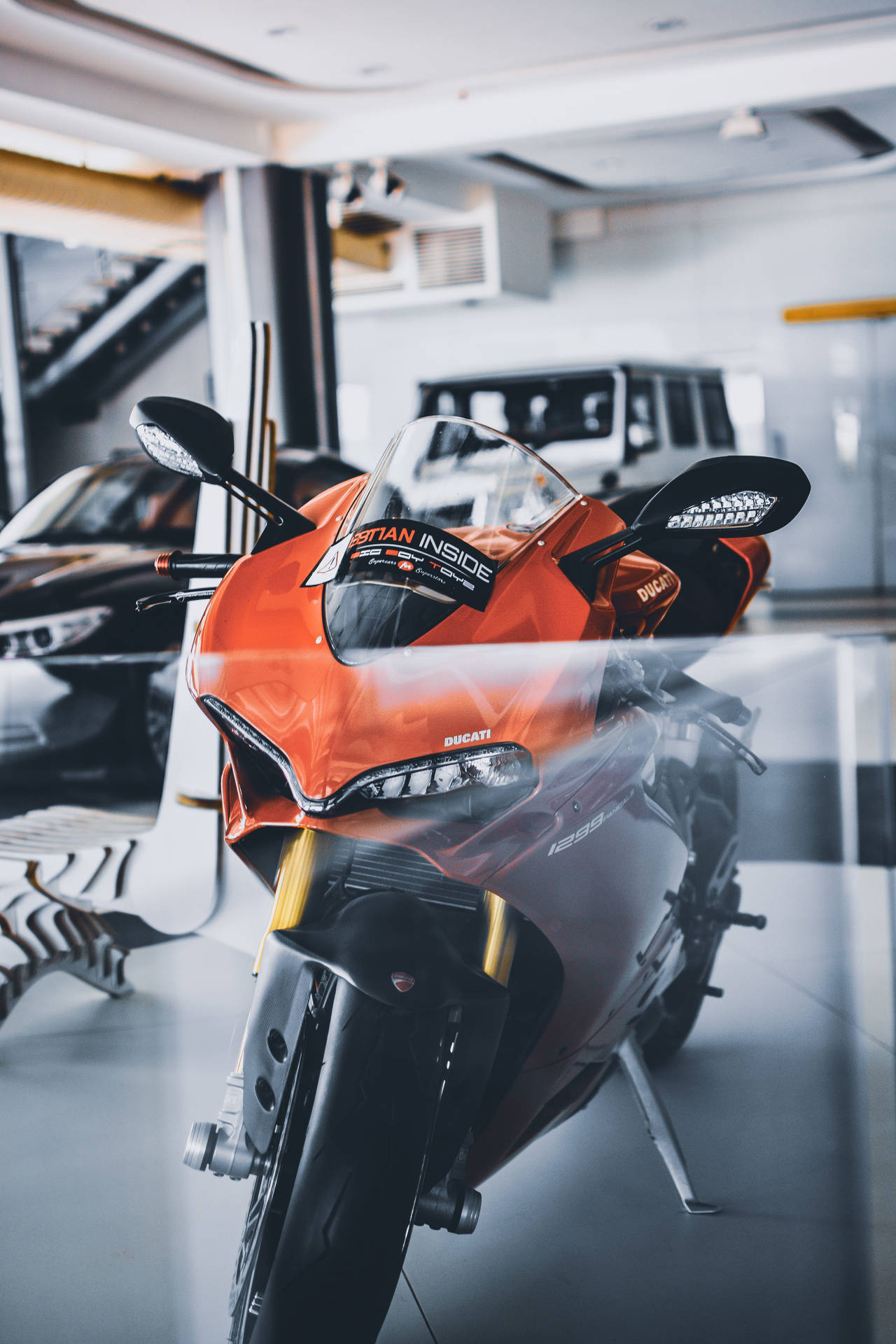 橙色Ducati電單車展示在豪華車陳列室中。