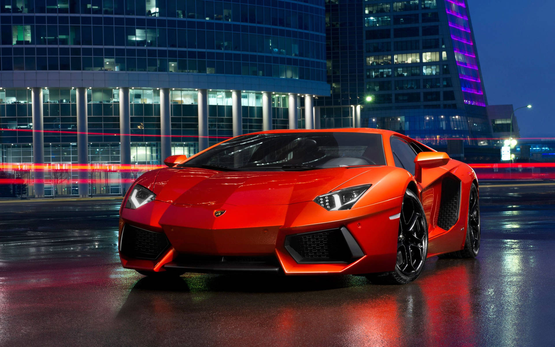 紅色林寶堅尼 Aventador 停泊在潮濕的城市街道上，夜晚有霓虹燈和車流線條。