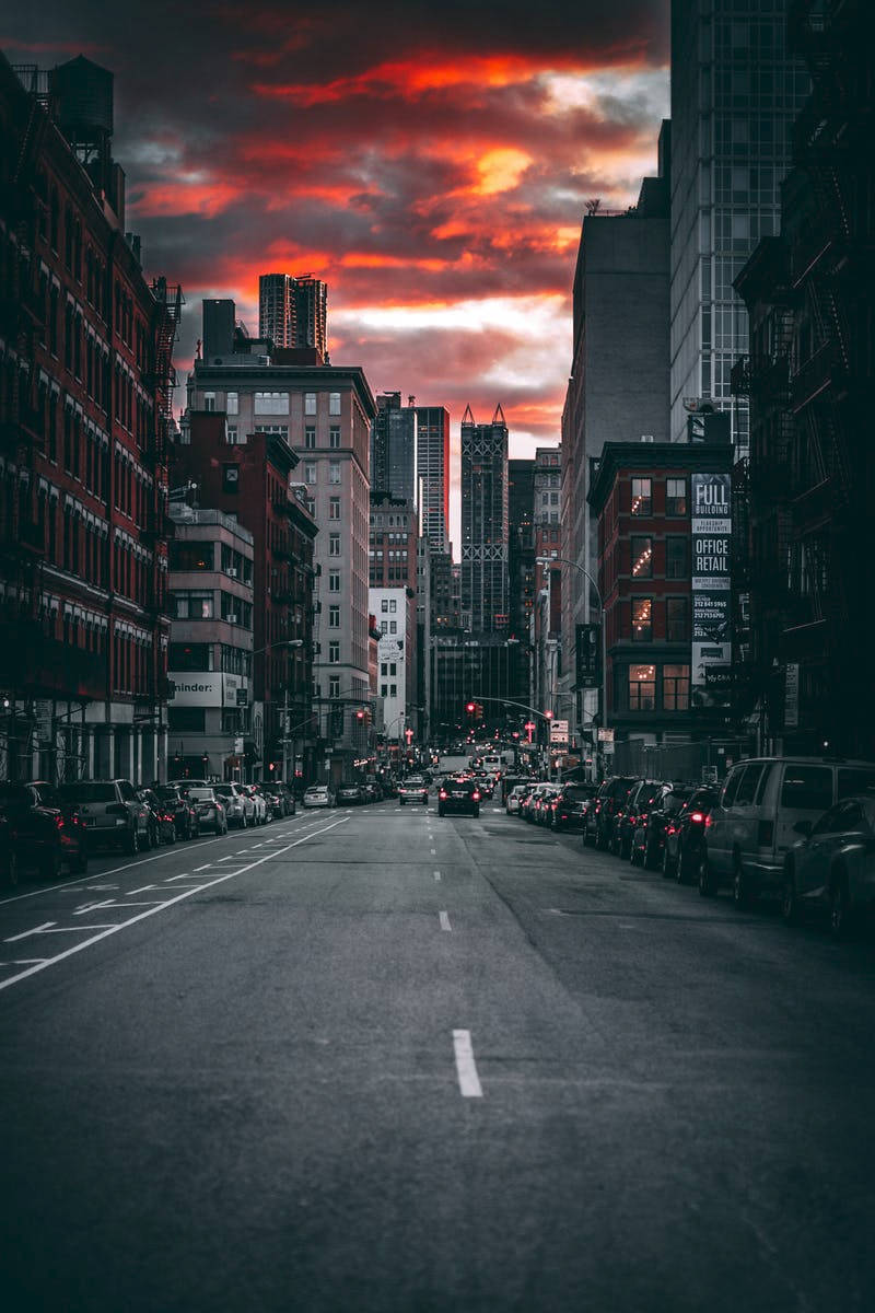 日落時分的城市街道，火橙色雲層和高樓大廈
