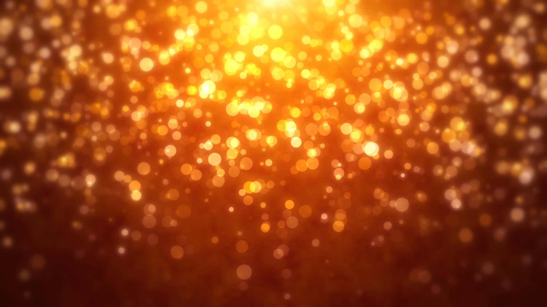 橙色閃粉金光 壁紙 — 一片燦爛的金色散景燈光，在深琥珀色背景下溫暖地發光。