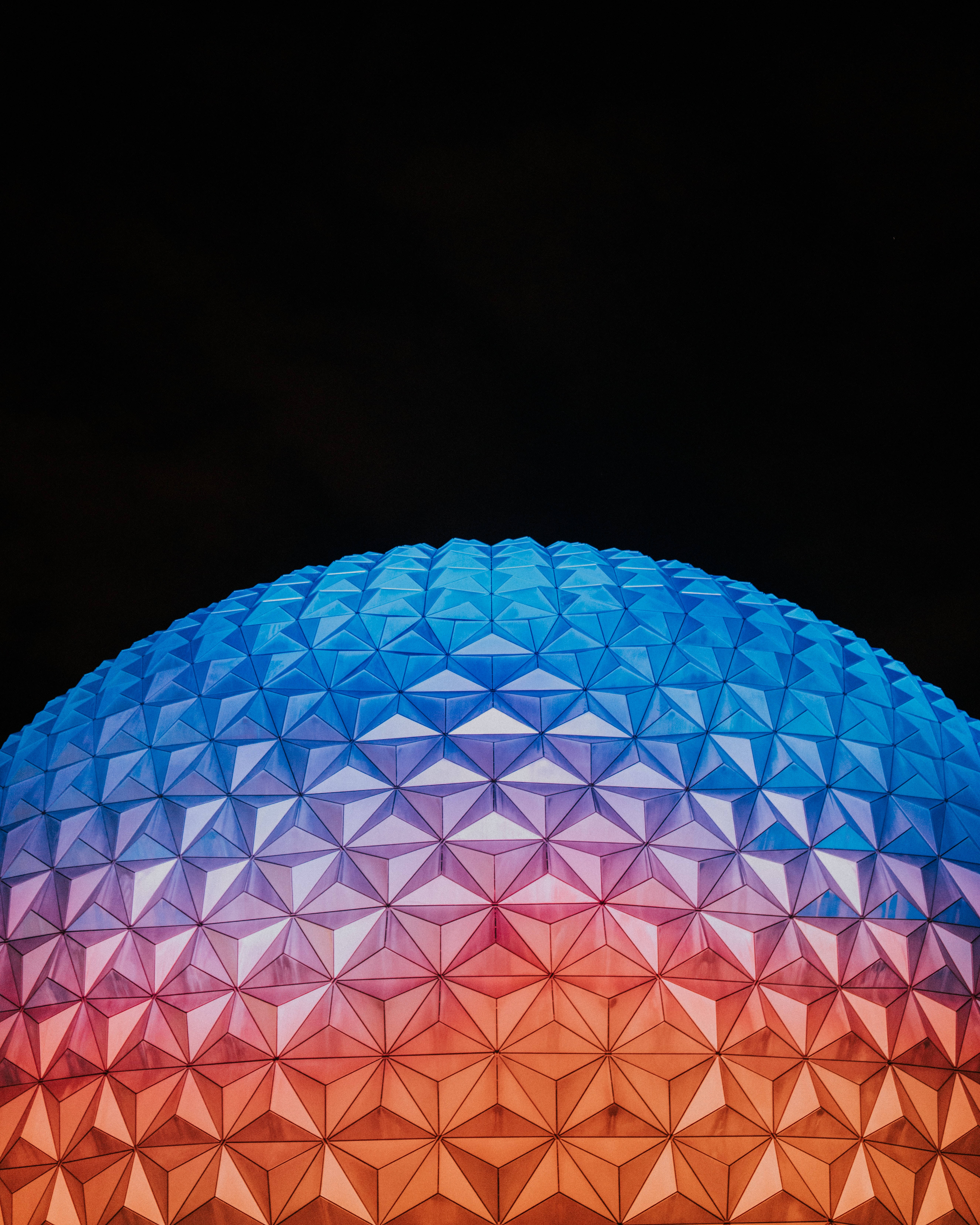 橙藍漸層 Epcot 球體 壁紙 — 幾何圓頂在黑色夜空下從藍色過渡到橙色。