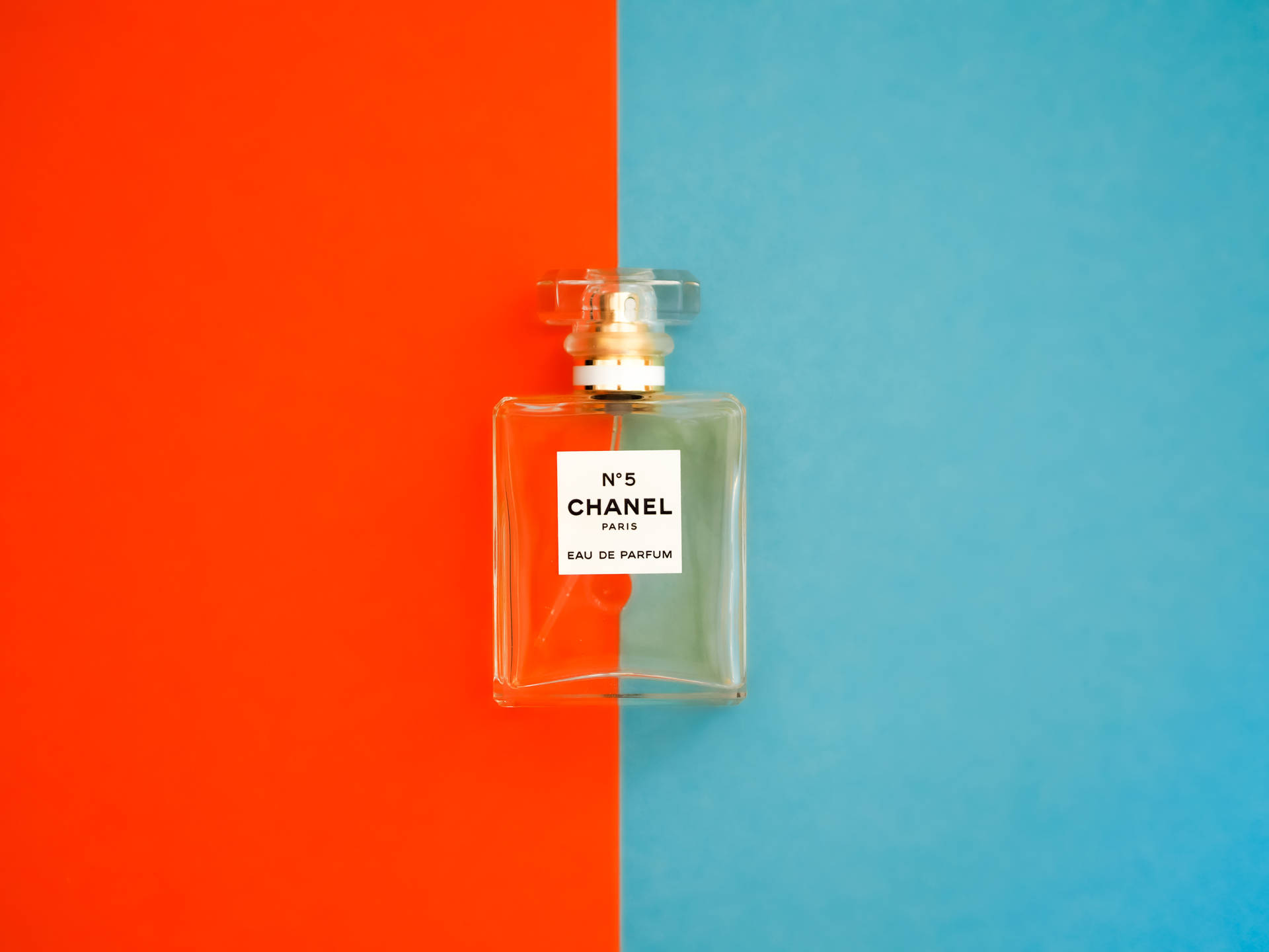Chanel No 5 香水瓶在橙色和藍色背景前