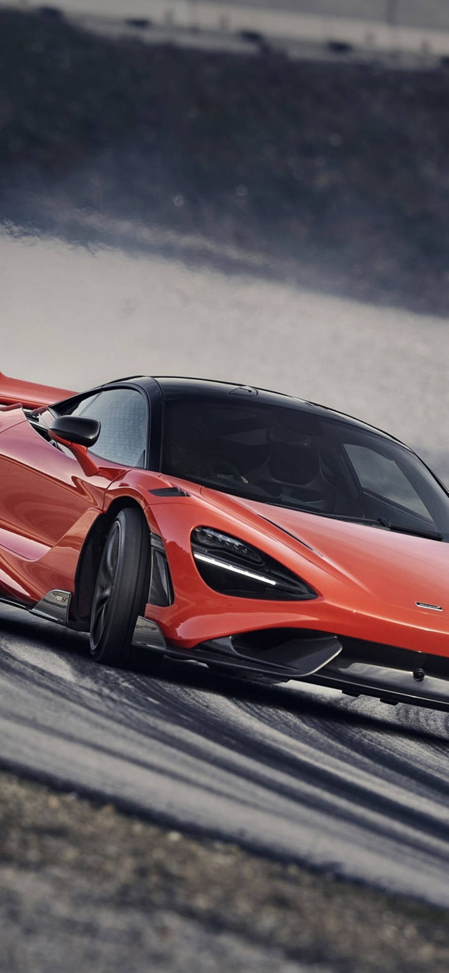 橙色McLaren跑車在賽道上飄移並冒煙