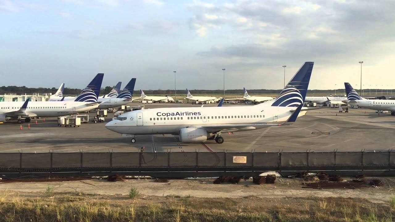 Copa Airlines 飛機停泊在機場停機坪，前景有圍欄和草地。
