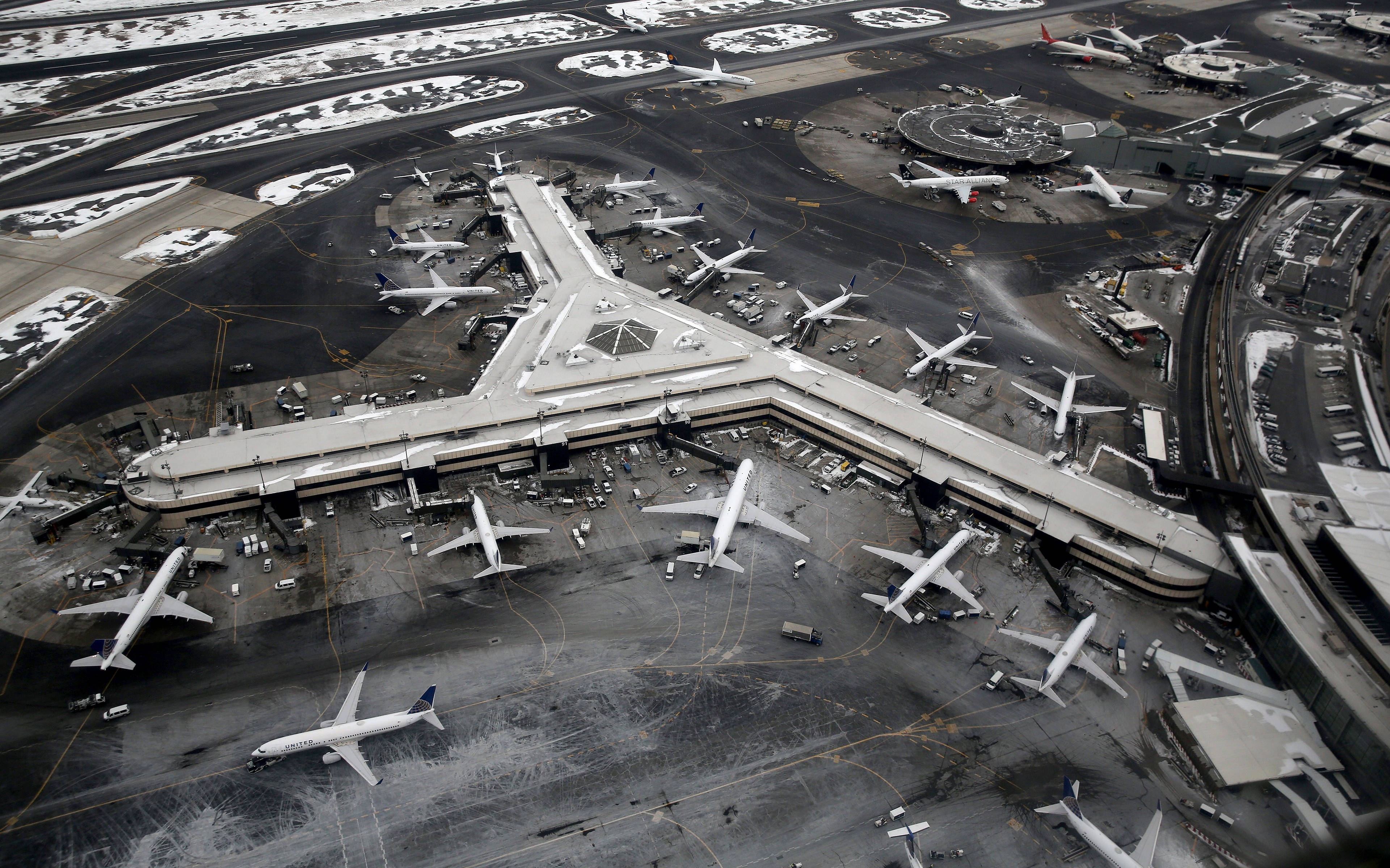 機場空中俯瞰 壁紙 — 鳥瞰一個被雪覆蓋的機場客運大樓，大量飛機停泊在登機閘口和滑行道。