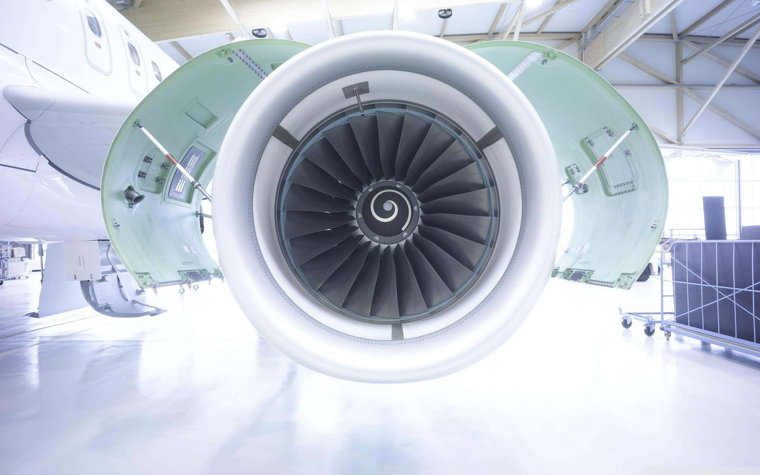 Jet Engine 桌布 壁紙 — 機庫內噴射引擎渦輪葉片的特寫，引擎艙門打開，上方照明明亮。