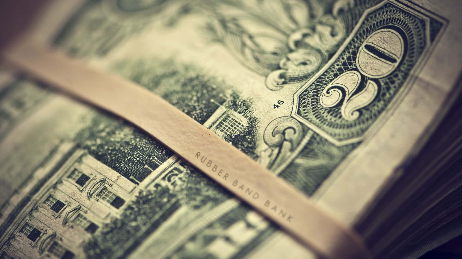 一疊復古綠色美元鈔票，由一條標有 rubber band bank 的橡筋綁著。