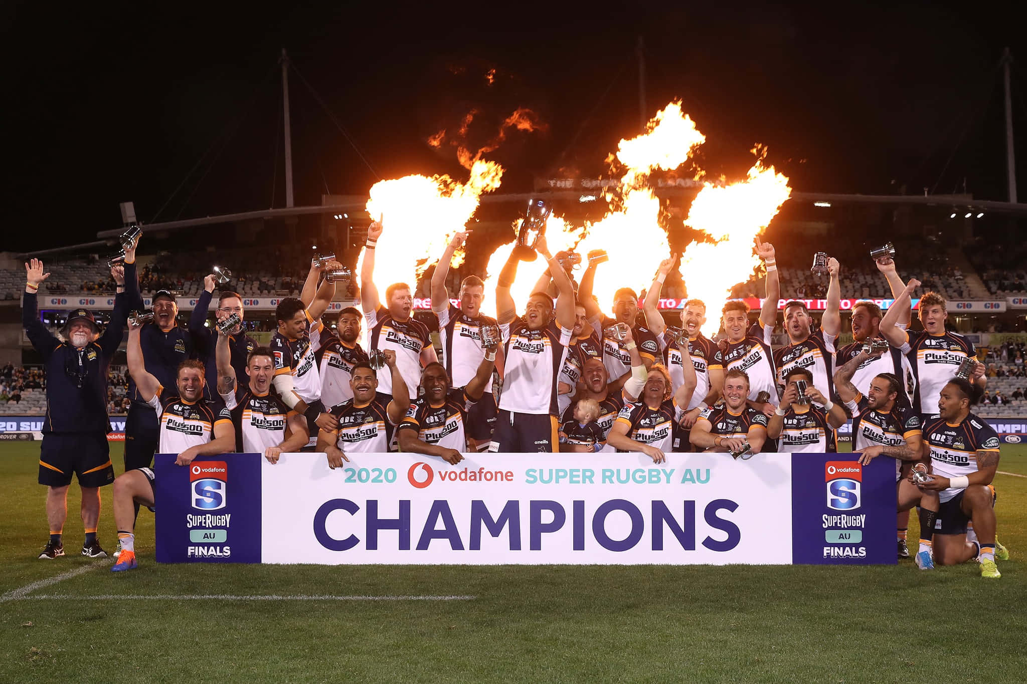 Brumbies 桌布 壁紙 — 欖球隊在夜間於體育場用火炬和獎盃慶祝冠軍勝利。