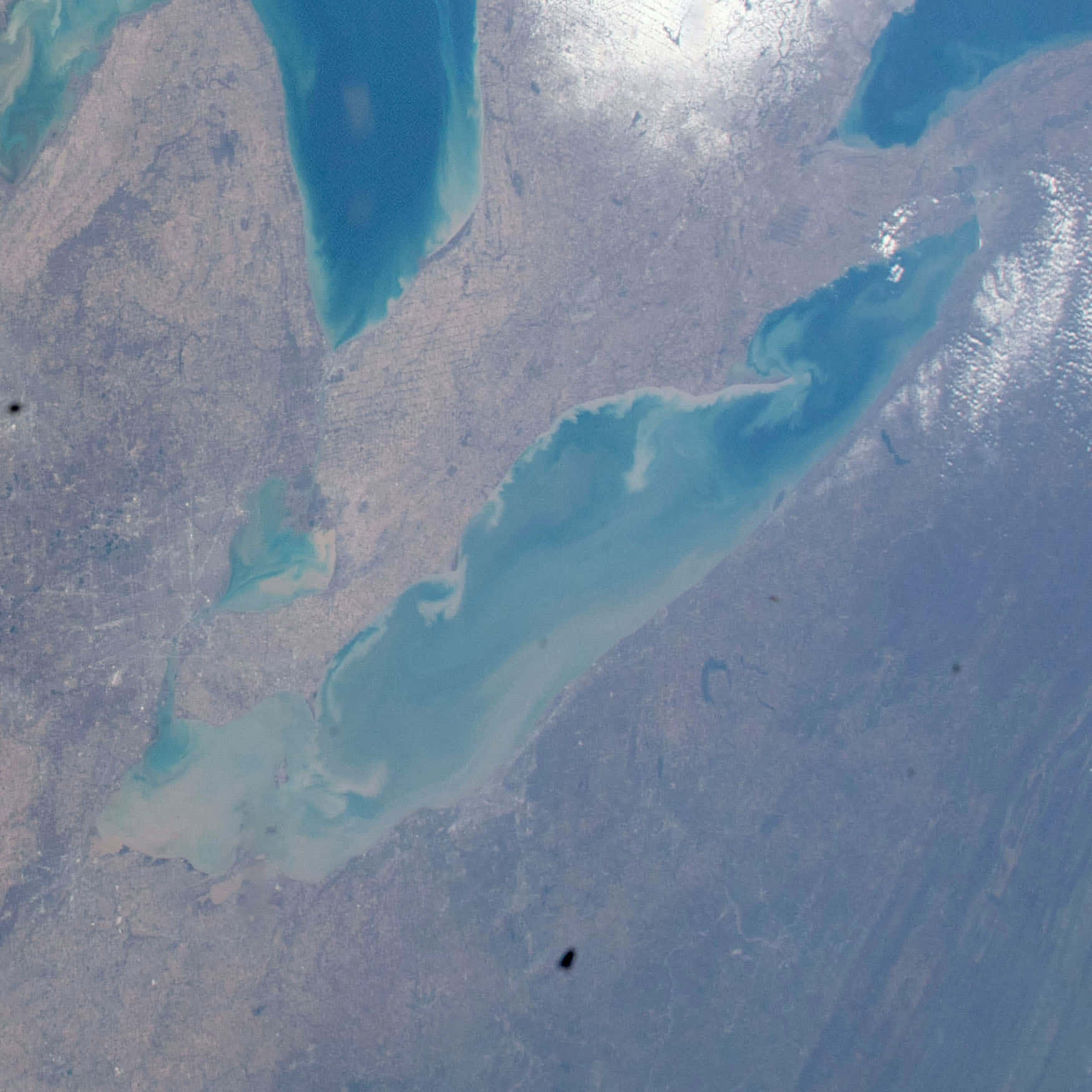 衛星視角下切割乾旱陸地的碧綠海灣，可見水流。