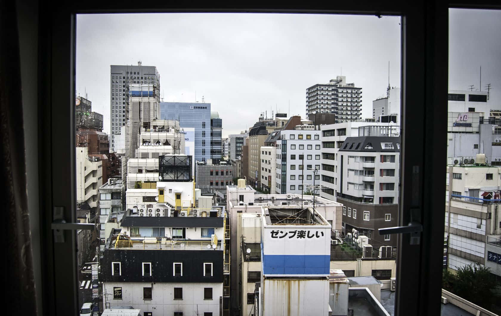 從窗戶俯瞰陰天下密集的日本城市景觀。
