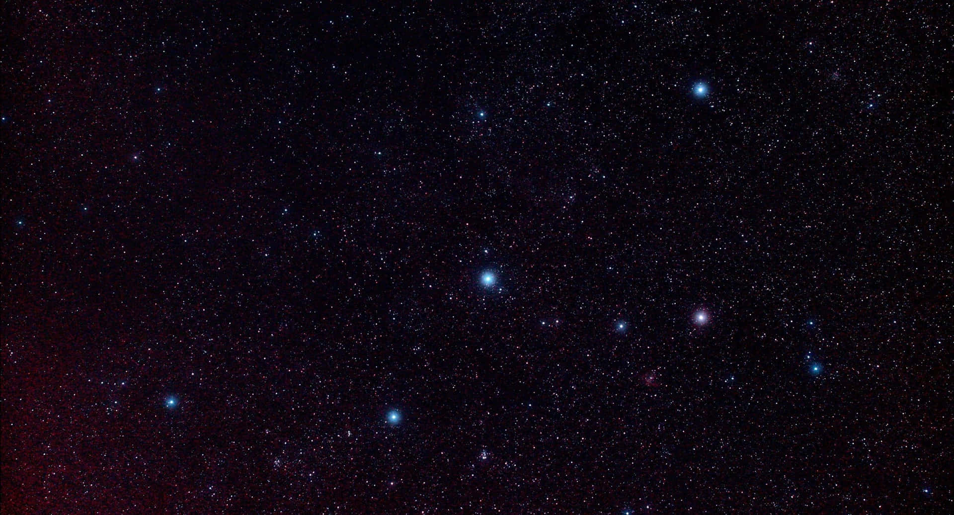 繁星點點的夜空，有發光的星星和微弱的紅色星雲。