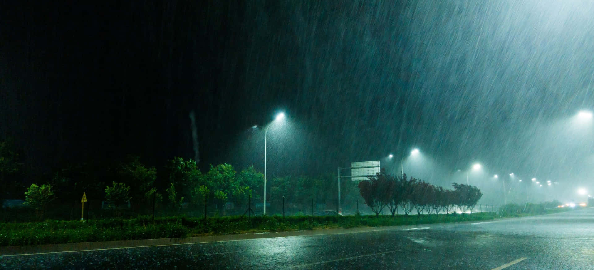雨夜街道，發光的街燈和潮濕的路面。