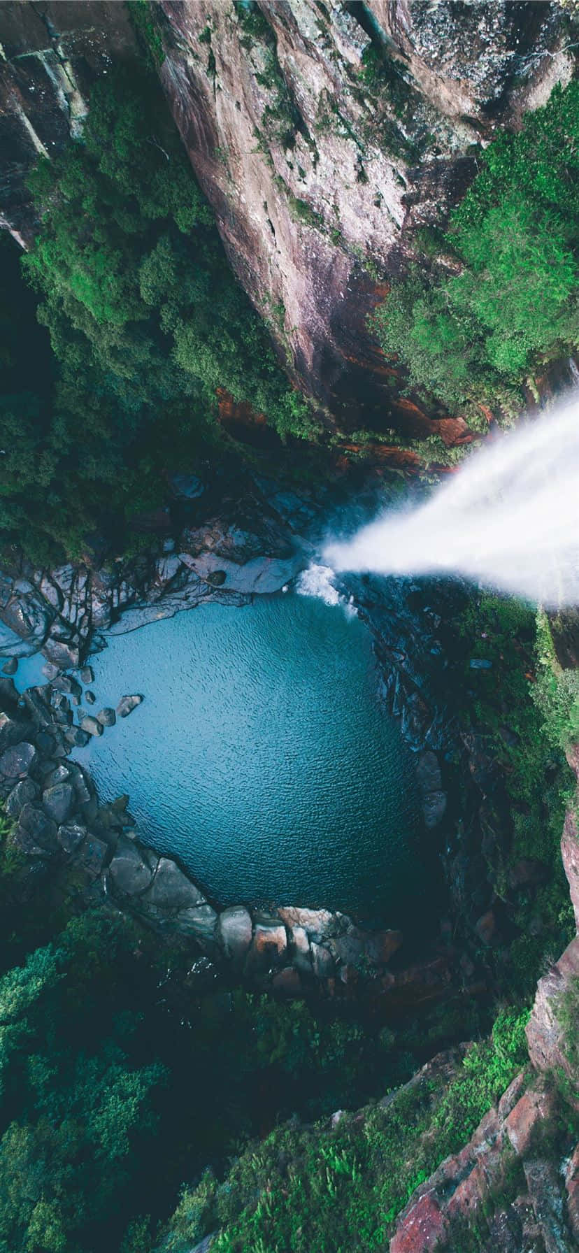 欣賞最壯觀的目的地：大峽谷 壁紙 — 俯瞰一個強大的瀑布傾瀉入一個翠綠峽谷中的碧綠水池。