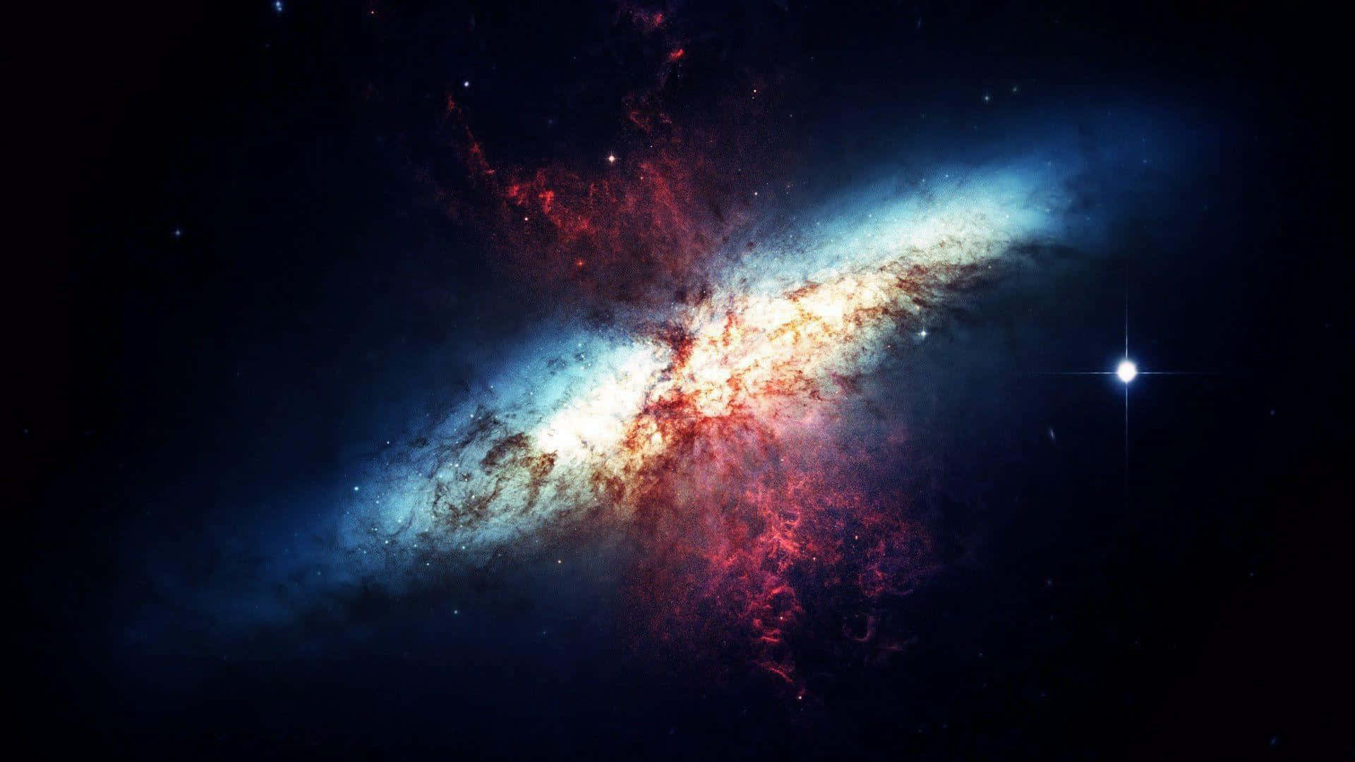 欣賞涼藍星系與其璀璨星辰之美 壁紙 — 一個充滿活力的螺旋星系，旋轉著藍色和紅色的宇宙塵埃，背景是佈滿星星的黑色虛空，附近有一顆明亮的星星。