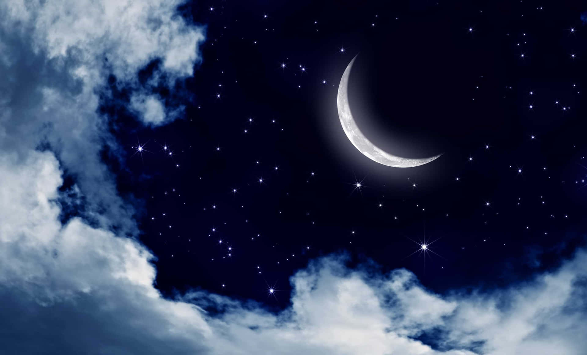 新月和星星從深藍色夜空的薄雲中探出頭來。
