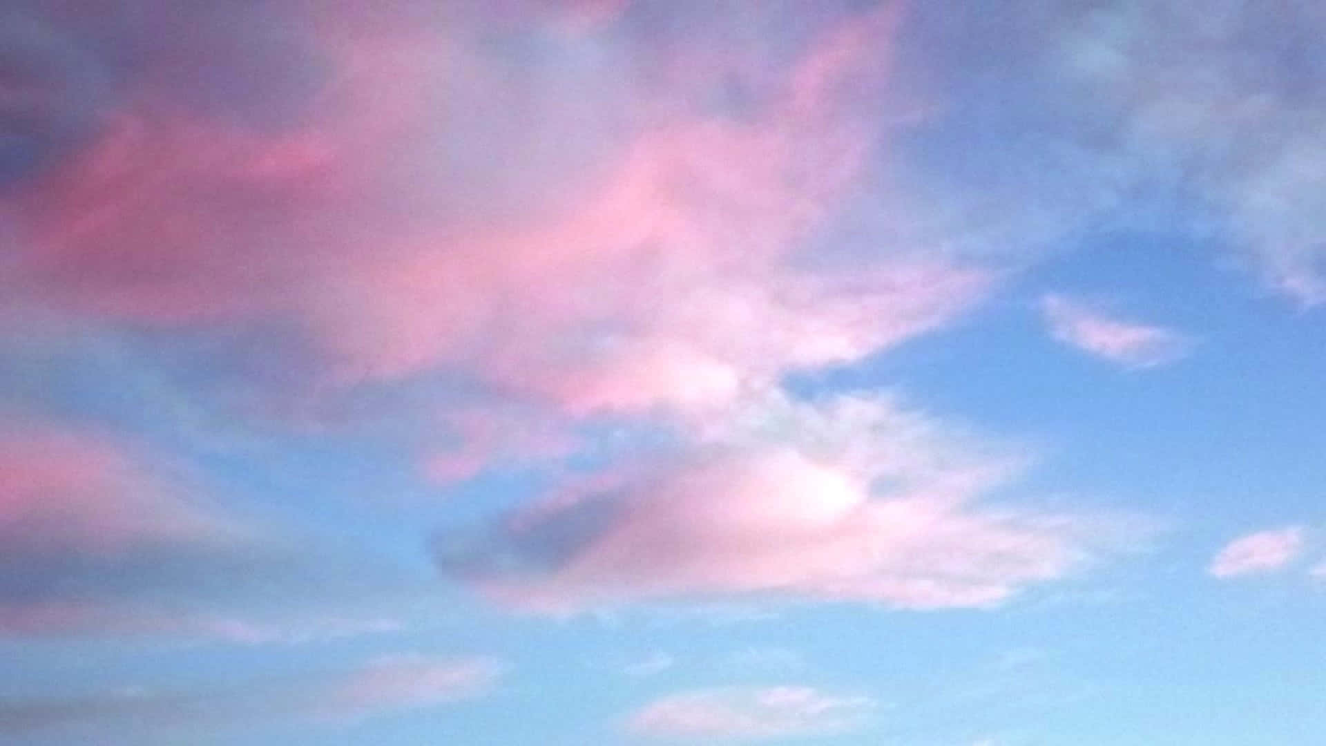 粉彩粉紅色和藍色雲朵在寧靜的暮色天空中飄移。