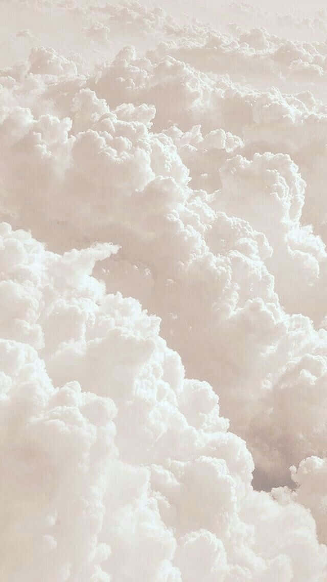 欣賞美學日落的寧靜之美 壁紙 — 柔軟質感的蓬鬆白雲毯子沐浴在溫暖的粉彩光中。