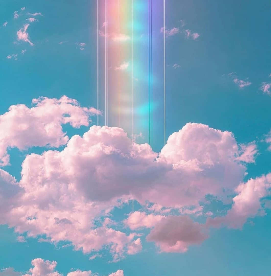 藍綠色天空下的粉紅色雲朵和垂直彩虹光束