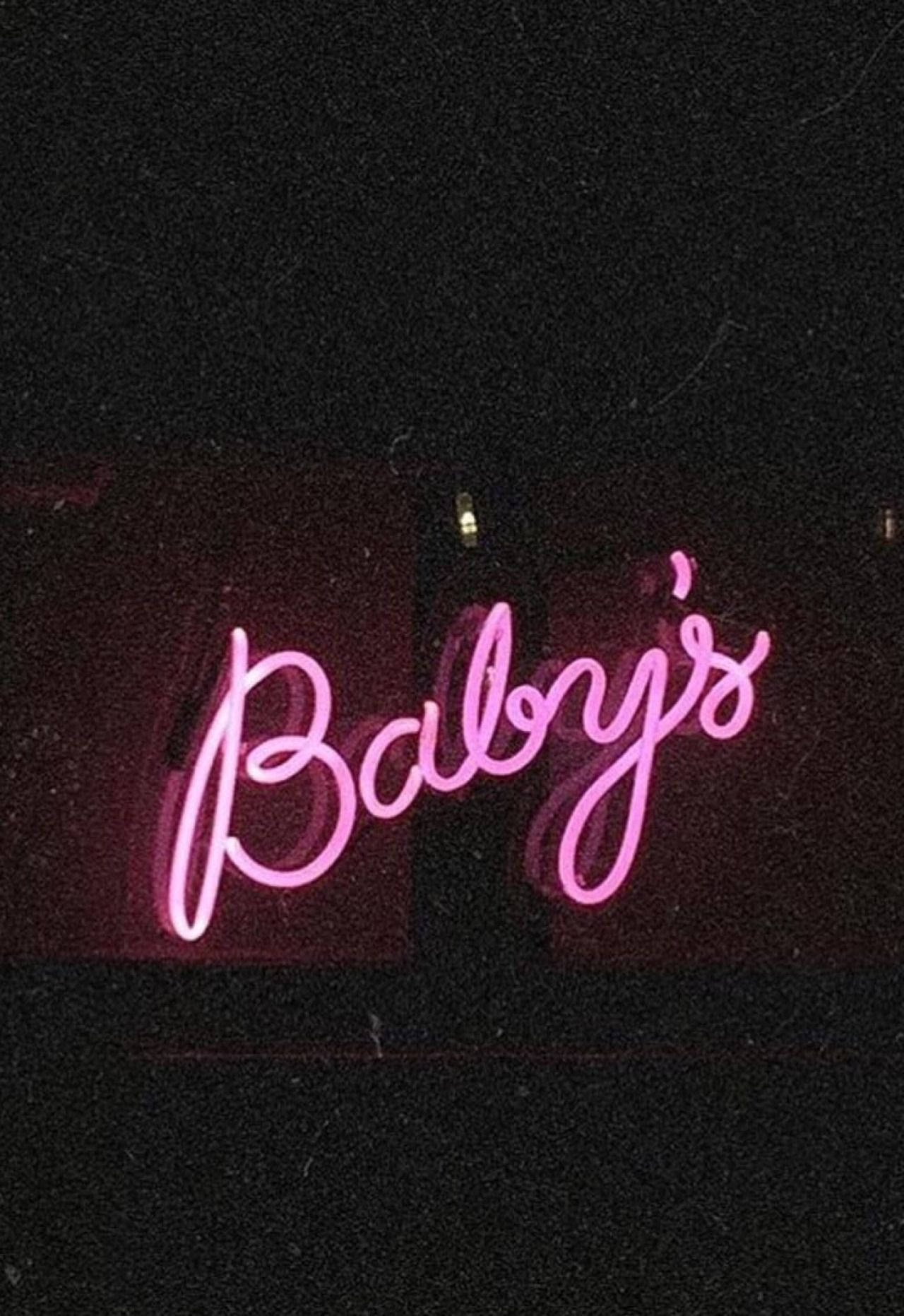 粉紅色霓虹燈牌，上面寫著 Baby's，在深色牆壁上。